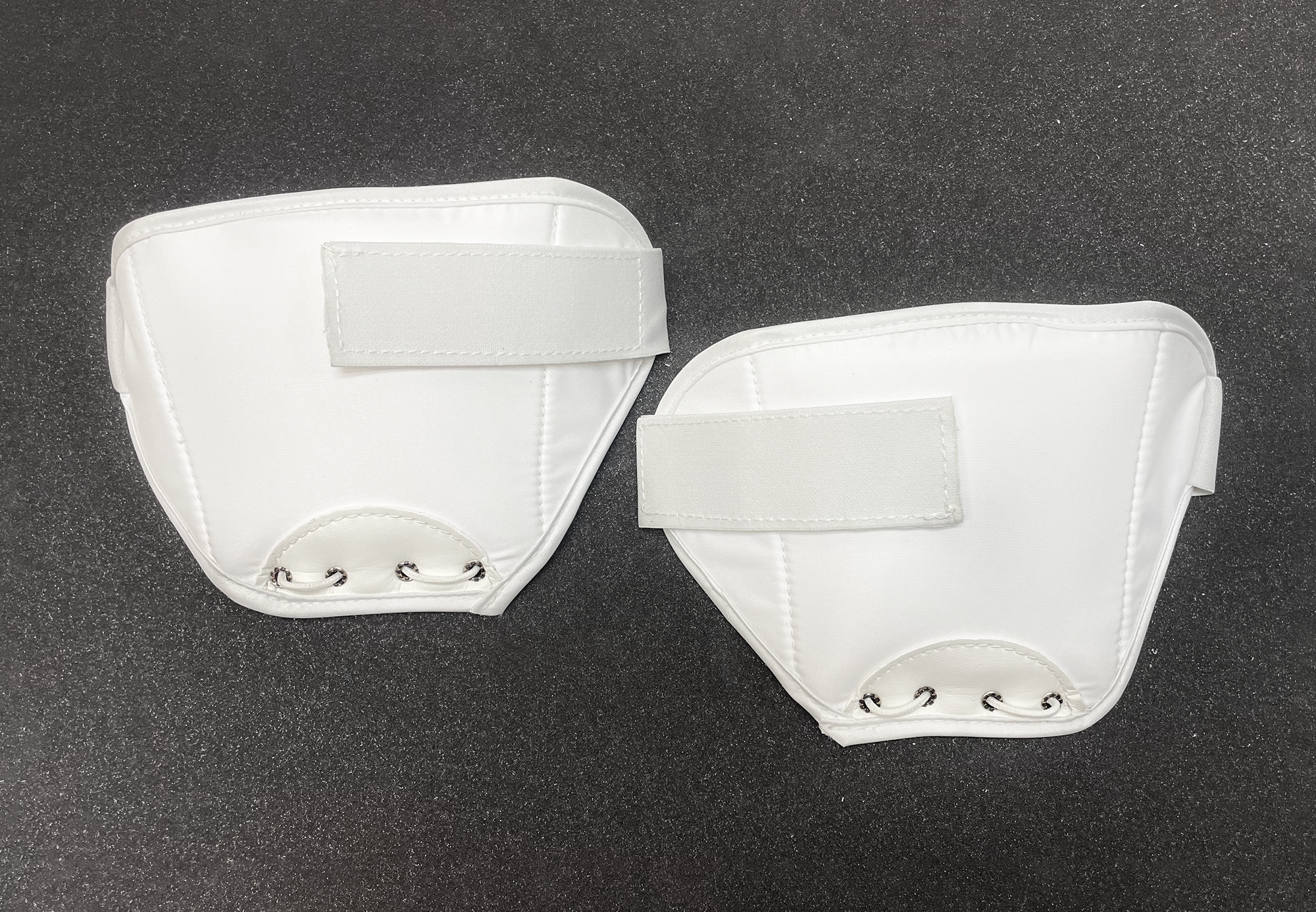 Top of two white thigh guards